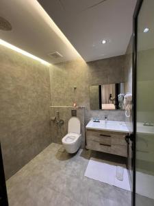 a bathroom with a toilet and a sink at افاق بلس للشقق المخدومه in Hafr Al Baten