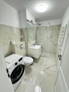 une salle de bain blanche avec une machine à laver à l'intérieur dans l'établissement Luxury Avanera Towers Apartments Parking included, à Suceava