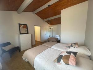 a bedroom with two beds and a chair at Villa Kéana en Sud Ardèche, avec piscine in Lachapelle Sous Aubenas