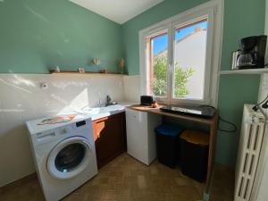a laundry room with a washing machine and a window at Le beau séjour in Grosbreuil