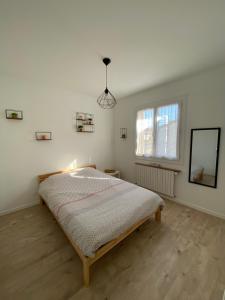 a bedroom with a bed in a white room at Le beau séjour in Grosbreuil