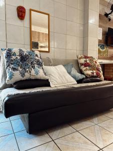 a couch with pillows on it in a room at Pousada Mar Aberto Pinheira in Pinheira