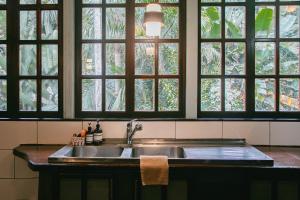 a kitchen with a sink and a bunch of windows at Casa de Mono Bocas in Big Creek