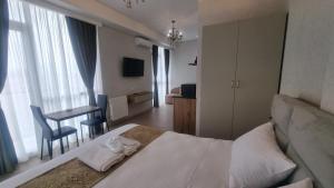 una camera d'albergo con letto e tavolo con sedie di Sky by the river a Tbilisi City