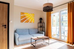 a living room with a blue couch and a table at Aruka - Apartamenty Bardzo Blisko Plaży in Władysławowo