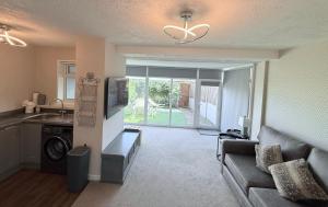 a living room with a couch and a kitchen at The Beachcomber - seafront, free parking, free wifi in Cleveleys