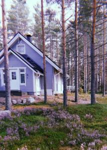 una casa morada en el bosque con árboles en Villa, en Kalajoki