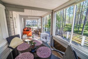 un porche cubierto con mesas y sillas en Villa, en Kalajoki