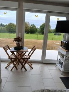 a living room with a table and chairs and sliding glass doors at la chambrée in Leschelles