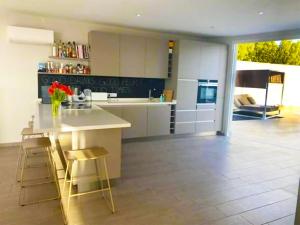 a kitchen with a island with stools and a counter top at Paraiso House in Callao Salvaje