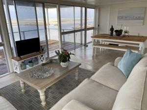 a living room with a couch and a tv and a table at Moonshine in Hermanus