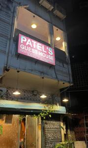 スーラトにあるPatel's Guest Houseの店の側面のピンクの看板