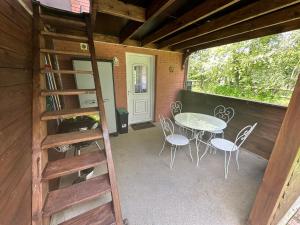 a patio with a ladder and a table and chairs at Maisonnette in Marcei