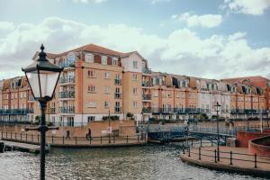 a street light next to a river with buildings at Lock & Quay - waterfront oasis in Pevensey