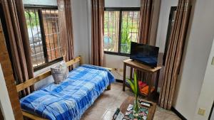 een slaapkamer met een bed, een tv en ramen bij Cómodo Dúplex en Puerto Iguazú in Puerto Iguazú +37 foto's