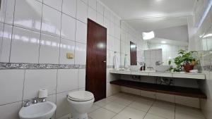 een badkamer met een toilet, een wastafel en een spiegel bij Cómodo Dúplex en Puerto Iguazú in Puerto Iguazú