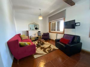 a living room with two chairs and a tv at Casa Eva e Eduardo in Macedo de Cavaleiros