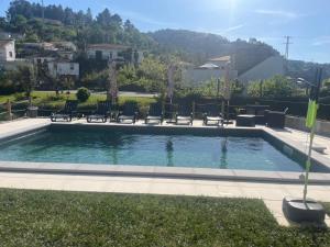 a swimming pool with chairs in a yard at CRASTO PAYVA DOURO NATURE in Castelo de Paiva