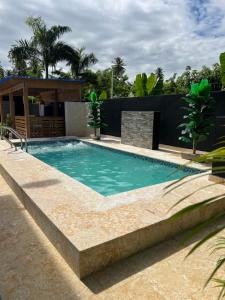 a swimming pool with a stone retaining wall at Escondite en Nagua in Nagua