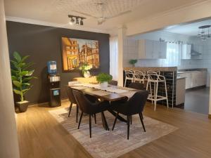 a dining room and kitchen with a table and chairs at Mudzini gardens - Luxury villa with a pool in Mombasa