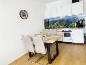 a kitchen with a wooden table and white cabinets at 1-Zi-Ferienwohnung Säulingsblick in Oy-Mittelberg +20 photos