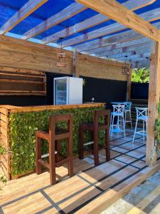 a wooden deck with a bar and stools at Escondite en Nagua in Nagua