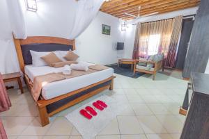 a bedroom with a bed and two red slippers at Almasi in Ukunda