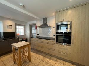 a kitchen with stainless steel appliances and a wooden table at La Belle Vie aux Quartes in Rendeux