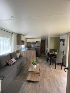a living room with a couch and a table at La Carabasse Mobilhome Vias plage in Vias