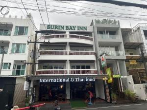 a building with a sign that reads sunbury bay inn at Surin Bay Inn in Surin Beach