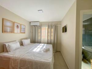 a bedroom with a white bed and a sink at AP01 de 2 suítes para até 8 pessoas em condomínio a 3 minutos a pé da praia de Taperapuan in Porto Seguro +26 photos