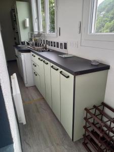 a kitchen with white cabinets and a black counter top at Appartement paisible in Eaux-Bonnes