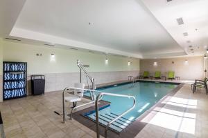 a swimming pool in a room with chairs and tables at SpringHill Suites by Marriott Oklahoma City Downtown in Oklahoma City