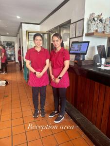 a man and a woman standing in front of a counter at Surin Bay Inn in Surin Beach