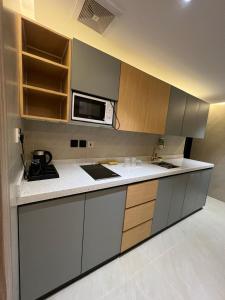 a kitchen with a counter top with a microwave at افاق 1 بلس للشقق المخدومه in Hafr Al Baten