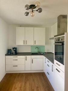 a kitchen with white cabinets and a ceiling at Ferienwohnung Wiesenglück in Burg Kauper +2 photos