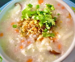 a bowl of soup with rice and greens on top at MD Kohlarn-Pattaya in Ko Larn