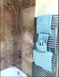 bagno con doccia, asciugamani blu e lavandino di Energy-Efficient Oasis Cozy Near DT Boulder and trails a Boulder
