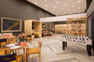 a restaurant with tables and chairs and a book shelf at Ginger Ahmedabad Vastrapur in Ahmedabad