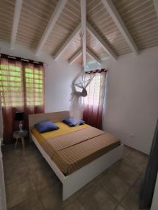 a bedroom with a bed in a room with windows at Appartement Multipliant in Deshaies