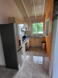 a kitchen with a stainless steel refrigerator and a window at Appartement Multipliant in Deshaies