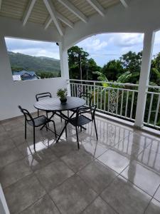 a patio with a table and chairs on a balcony at Appartement Multipliant in Deshaies