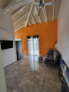 a living room with a couch and a flat screen tv at Appartement Multipliant in Deshaies