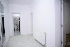 a white hallway with white walls and a mirror at Lisia Residence #1 in Piatra Neamţ