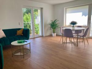 a living room with a couch and a table and chairs at Ferienwohnung Wiesenglück in Burg Kauper