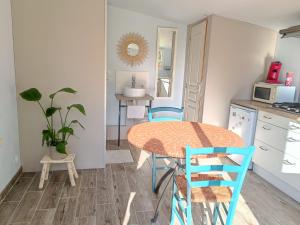 a kitchen with a table and chairs in a room at Le Petit Accent in Saint-Pierre-de-Bailleul