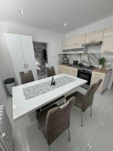 a kitchen with a white table and chairs at Peti apartman CENTRUM in Galanta