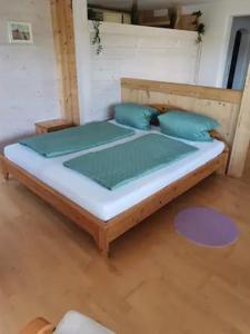 a wooden bed with blue pillows in a room at Schöne Ferienwohnung mit Terrasse in Malterdingen