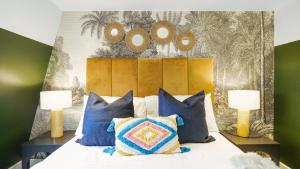 a bedroom with a bed with blue and yellow pillows at London Acton - hot tub, cinema & gaming room in London +38 photos