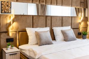 a bedroom with a bed with white sheets and pillows at Fashion Stay - Valentino Home - By OpenHouse in Giroc